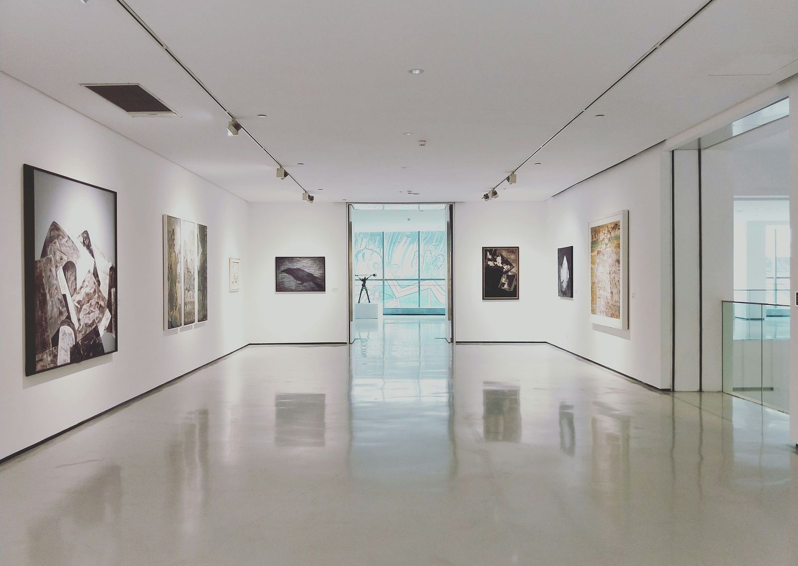 An overview of a museum with painting hung on all the walls